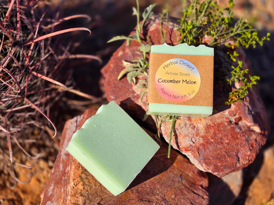 Two bars of our tallow based soap with cucumber and melon scent. The bars are a light green, one with the label on and one without.